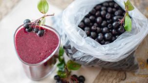 Baies d'açaï pourpres avec un smoothie dans un verre.