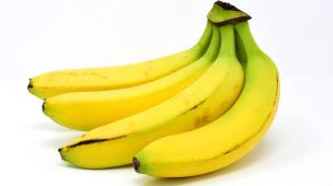 4 bananes jaunes en gros plan sur fond blanc