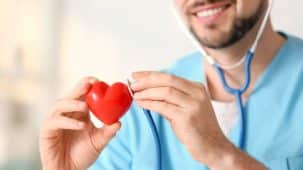 Coeur rouge (objet) dans les mains d'un cardiologue avec son stéthoscope.