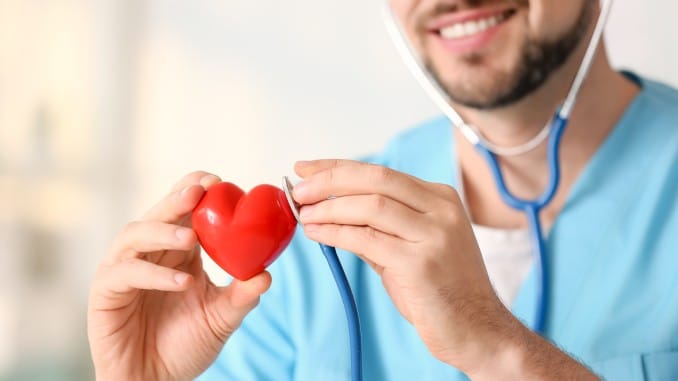 Coeur rouge (objet) dans les mains d'un cardiologue avec son stéthoscope.