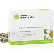 Boite de gélules contre les maux de tête et les migraines. On aperçoit une boite blanche et grise avec une grande camomille sur le packaging. Au fond, il y a des gélules sous blister.