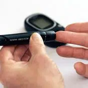 Diabète et acide alpha-lipoïque : une personne pique son doigt avec un appareil pour mesurer sa glycémie