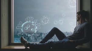 Homme à l'intérieur, sur le rebord d'une fenêtre, regardant la ville et les virus dans l'air.