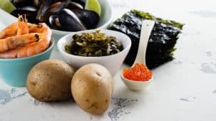 Aliments riches en iode : algues, crustacés, œufs de poissons et pommes de terre posés sur une table