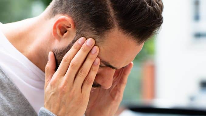 Homme qui se tient la tête avec fond vert