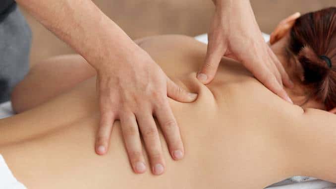 Technique du palper-rouler : massage avec pli cutané plein de bienfaits. Gros plan sur le pli créé par les mains du masseur sur le dos d'une femme.