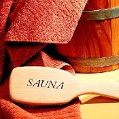 Brosse, seau et serviette pour sauna. Gros plan sur le mot sauna écrit sur la brosse.