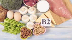 Vitamine B2 : aliments riches en riboflavine. Viande, œufs, champignons, fromage, amandes, céleri, soja sont disposés sur une table.